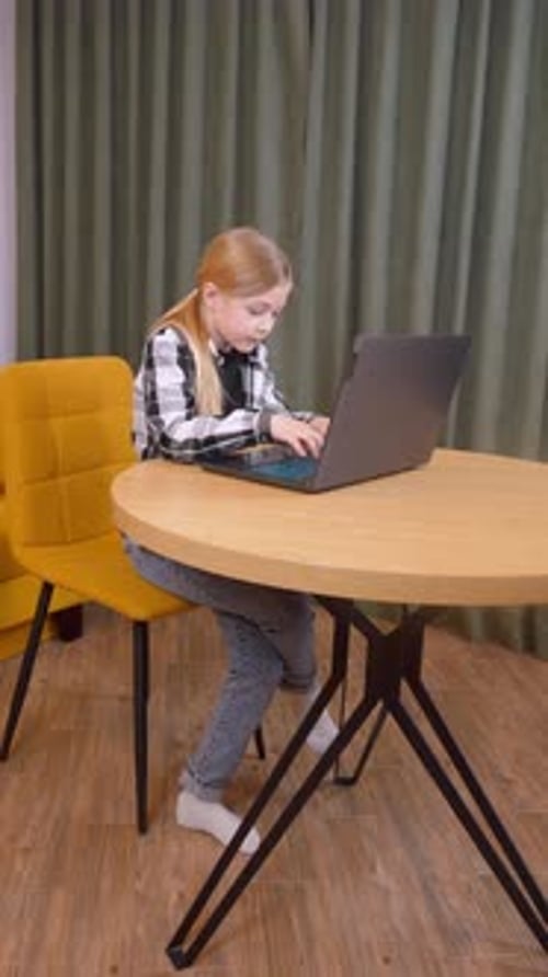 Chica joven programando usando una computadora portátil en casa
