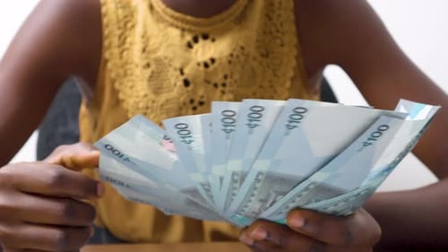 Woman Counting Ghana Cedi Currency Bills