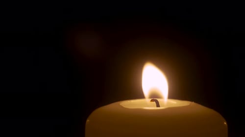 Burning Candle Isolated Close Up on Black Background