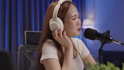 Side view of podcast host speaking into microphone during live session.