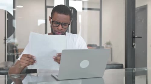 Young Adult Working at his Computer in Office