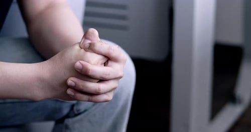 Man Fidgeting with Hands in Waiting Room