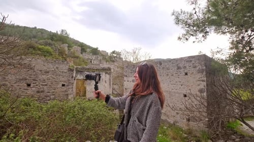 Woman with Camera Exploring Ruins in Natural Setting