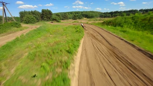 Motocross Rider Speeding Along a Rural Dirt Track