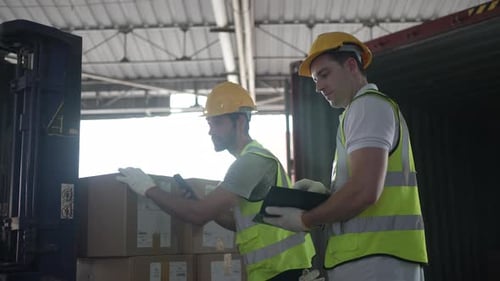 Blue collar workers are working at warehouse.