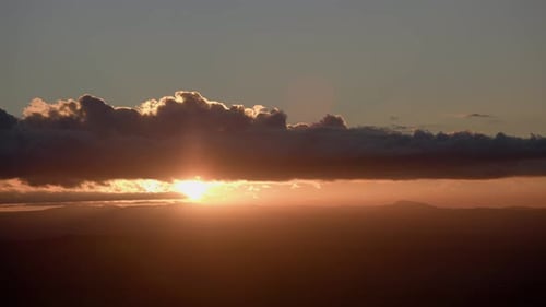 Vibrant Sunrise Through Clouds in Golden Hour