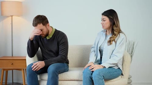Couple Arguing on Couch in Living Room