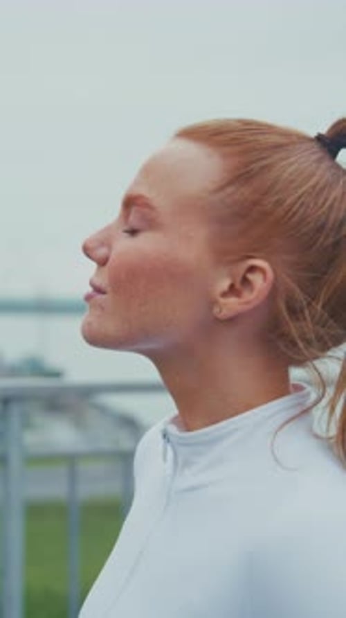 Woman Standing Still Outdoors in Urban Setting