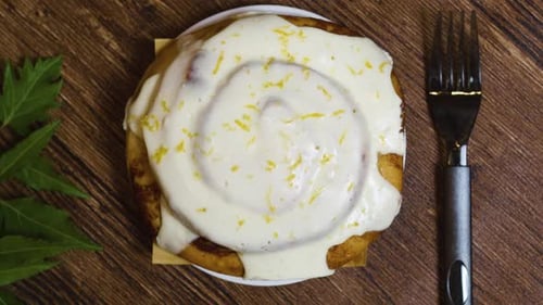 Zimtkäsebrötchen glasiert mit weißer Glasur, bestreut mit Zitronenschale, ruhen