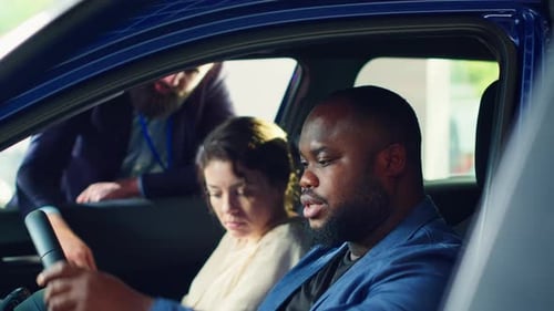 Salesman Explains Car to Couple at Dealership