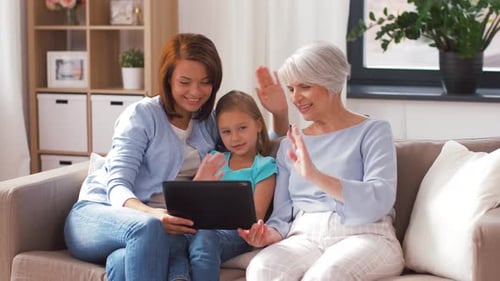 Three Generations of Women Using Tablet on Sofa