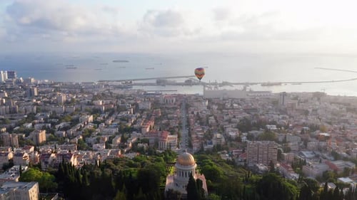 Hot air balloon above Haifa bay and Downtown area at sunrise, Aerial view