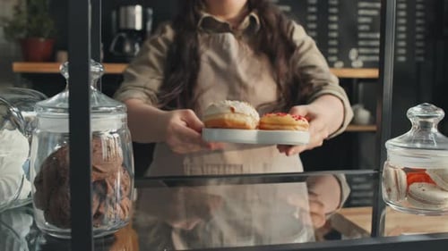 Cafe Worker With Disability Putting Plate With Donuts On Shelf