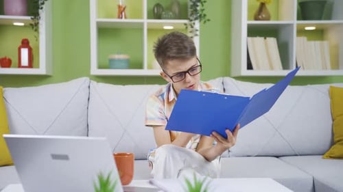 Kleiner Junge, der am Laptop und der Akte seines Vaters arbeitet. Er träumt davon, Geschäftsmann zu werden.