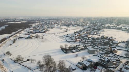 Aerial View of Private Homes with Snow Covered Roofs in Rural Suburbs Town Area in Cold Winter