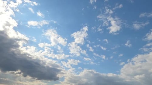 Sunny blue skies with light white clouds flying by the horizon.