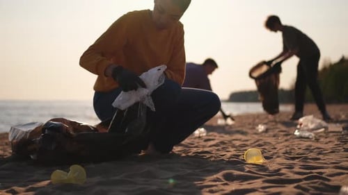 Freiwillige Aktivisten zum Tag der Erde sammeln Müllreinigung der Strandküstenzone, Frauen und Männer stellen