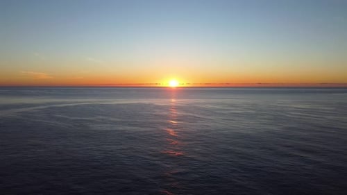 Sonnenaufgang über dem Meer mit Leuchtturm