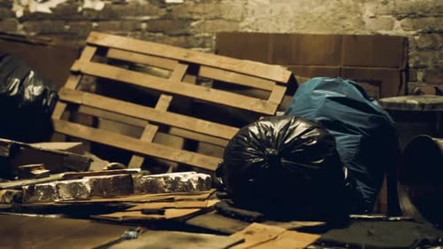 Discarded Waste Materials and Pallets in a Dimly Lit Storage Area at Night