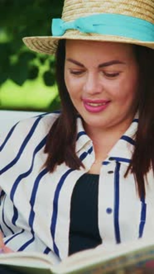 A Relaxing Afternoon A Woman in a Stylish Hat Enjoys Reading a Book Outdoors in a Lush Green Setting