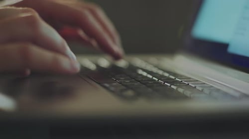 Hands Typing on Laptop Computer Keyboard Close-Up