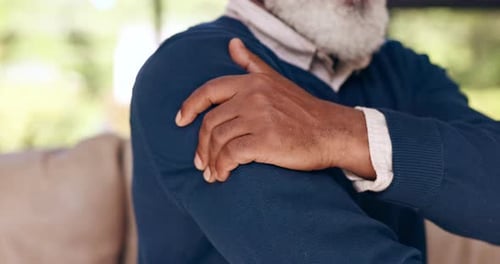 Senior Man Massaging Shoulder Close Up Indoors