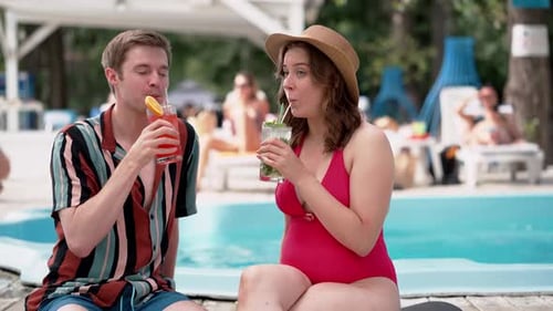 Couple Having Drinks By the Pool Enjoying a Sunny Day Creating a Happy Summer Holiday Atmosphere
