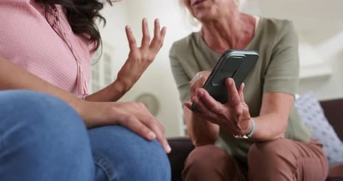 Adult and Senior with Smartphone Talking on Couch