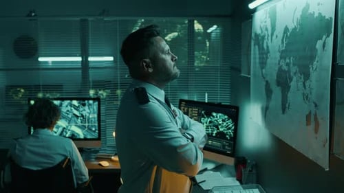 Man Reviews World Map in Office at Night