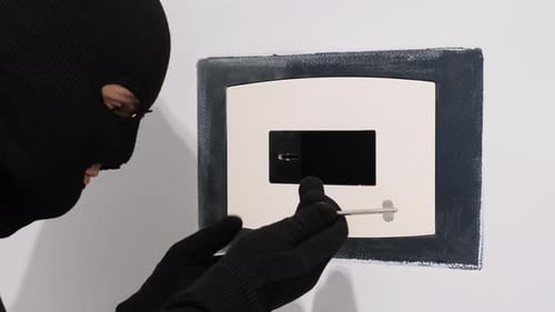 Gesetzesverletzer: Der Räuber öffnet die Tür des Safes mit verschiedenen Schlüsseln