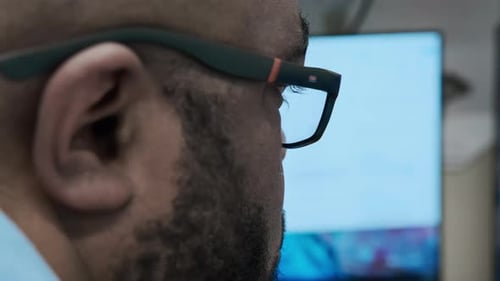 Close Up View of Portrait of Handsome Black Man Wearing Glasses Working on a Computer