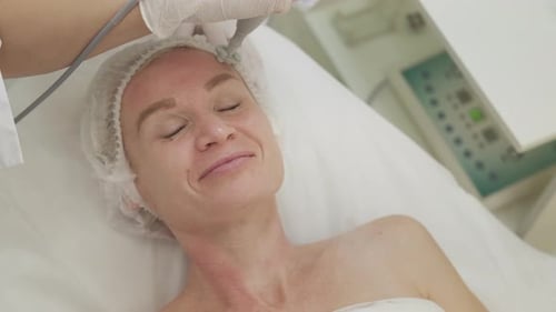 Woman Receives Facial Treatment in Clinic Setting