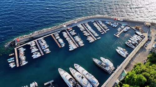 Vibrant marina filled with luxurious yachts along a scenic coastline during bright daylight hours