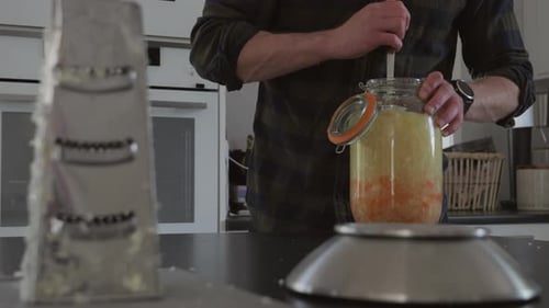 Homme caucasien préparant du kombucha fait maison, une boisson fermentée, tracking Shot, Slow motion