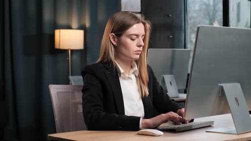 Woman Typing at Computer in Modern Office Setting