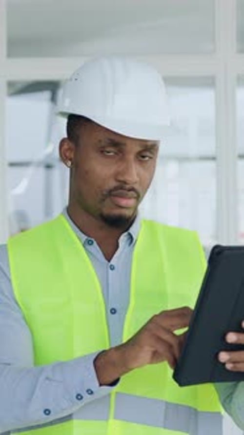 Focused Construction Worker Using Tablet on Building Site