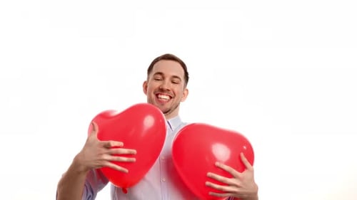 Cheerful Man Holding Two Heart Shaped Balloons
