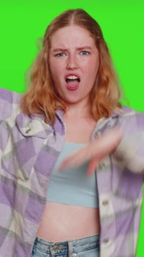 Expressive Young Woman Acting Silly Against Green Background