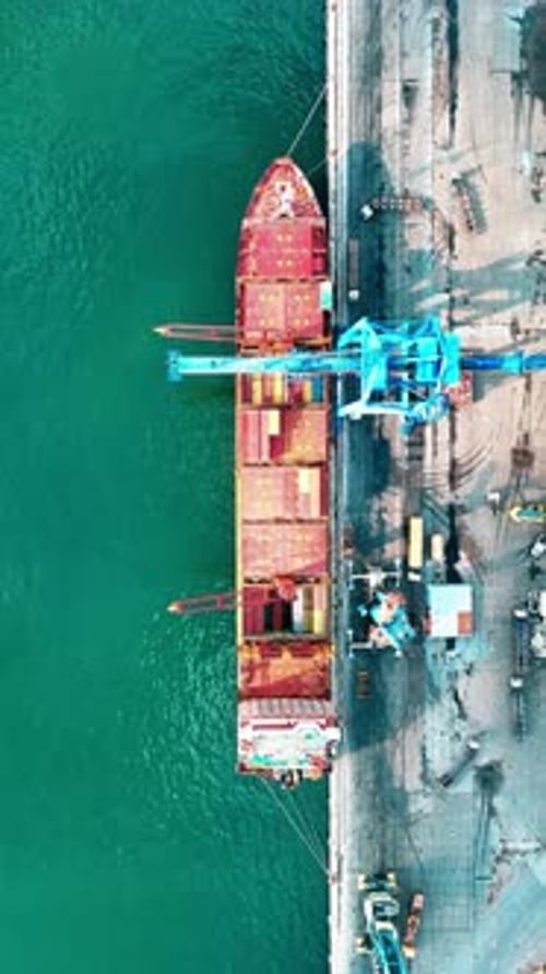 Vidéo verticale du port - Images filmées par drone de conteneurs, de cargos et de grues de chargement dans le port