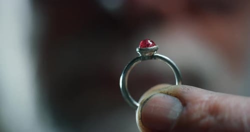 Slow motion of experienced goldsmith controlling a quality of just finished handmade jewelry ring