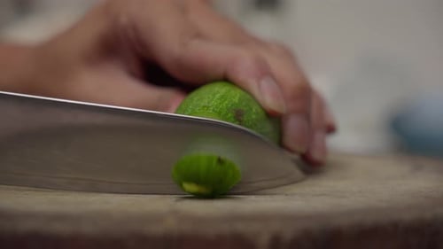 Slicing fresh cucumber into thin, even pieces with a kitchen knife