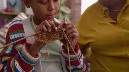 Child Learning How to Knit with Adult
