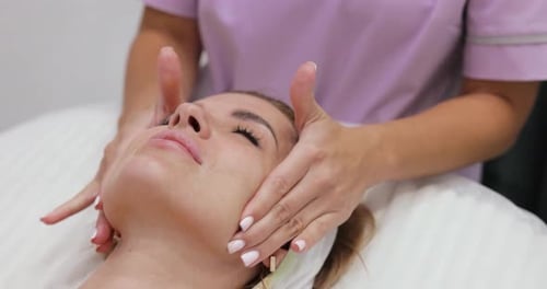 Woman Receiving a Relaxing Facial Massage at Spa