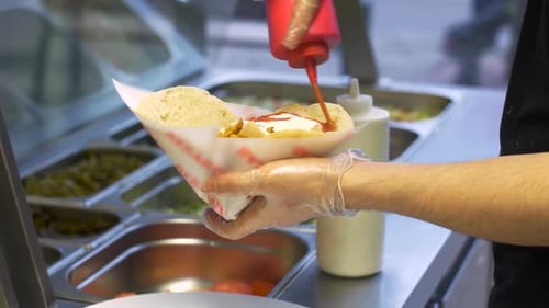 Delicious Street Food Adding Sauce to a Freshly Made Shawarma Sandwich