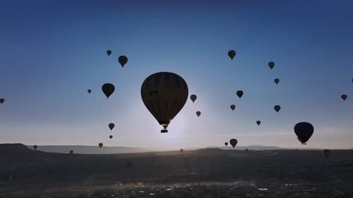 Hot Air Balloons Silhouetted Against Sunrise Landscape