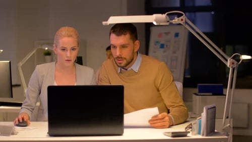 Conceito de negócios e prazos - equipe com laptop trabalhando no escritório noturno