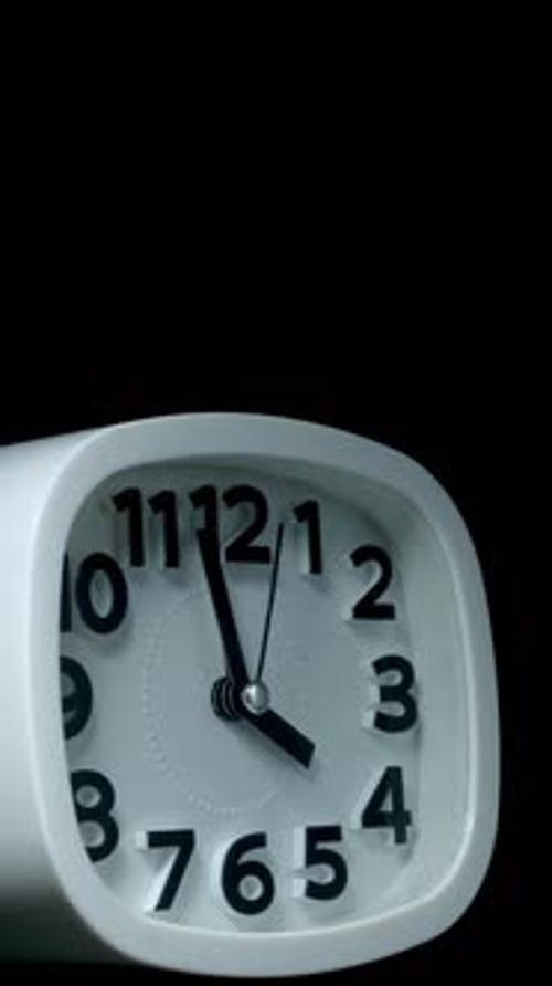 Vertical time lapse video of a clock time passing over a day to night on black background.