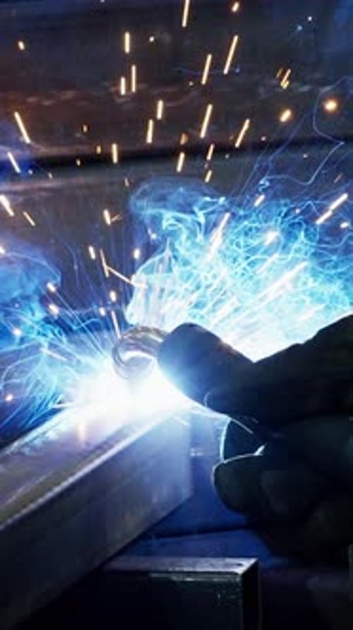 Welding Process Showcasing Sparks and Bright Arcs in a Workshop Setting