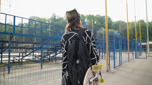 Woman Walks with Longboard Active Lifestyle Back View of Stylish Skater Female