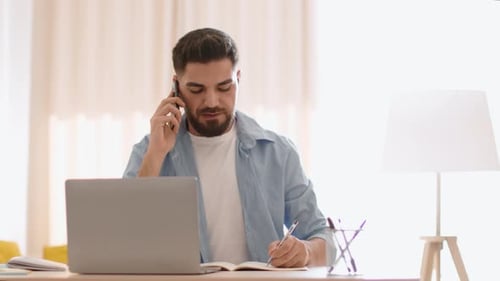 Man Working from Home on Laptop and Phone